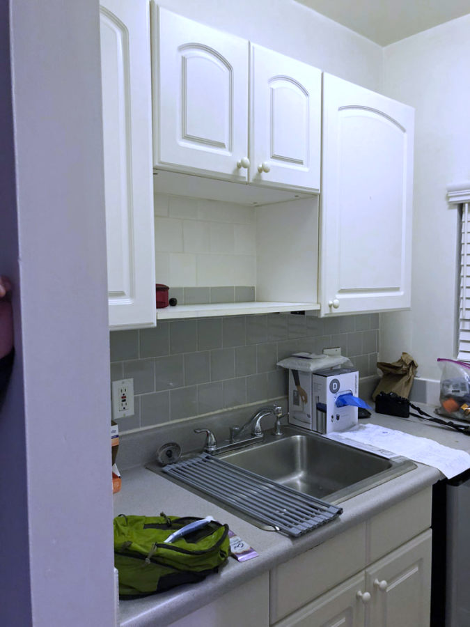 A kitchen with white cabinets and a sink Description automatically generated